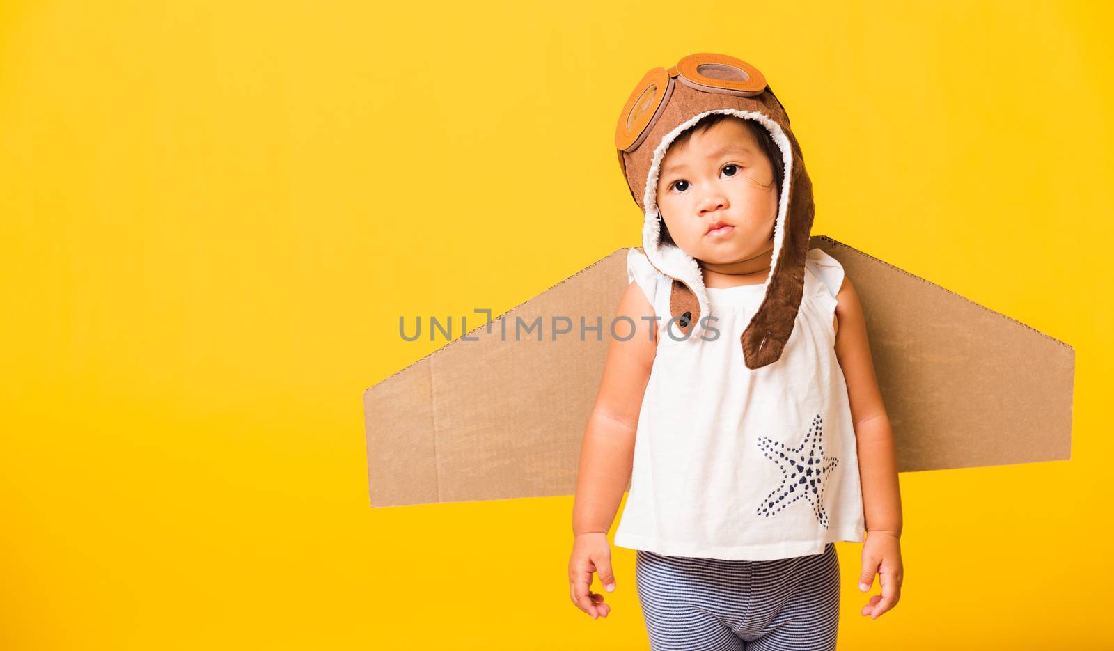 Kid little girl smile wear pilot hat play and goggles with toy c by Sorapop