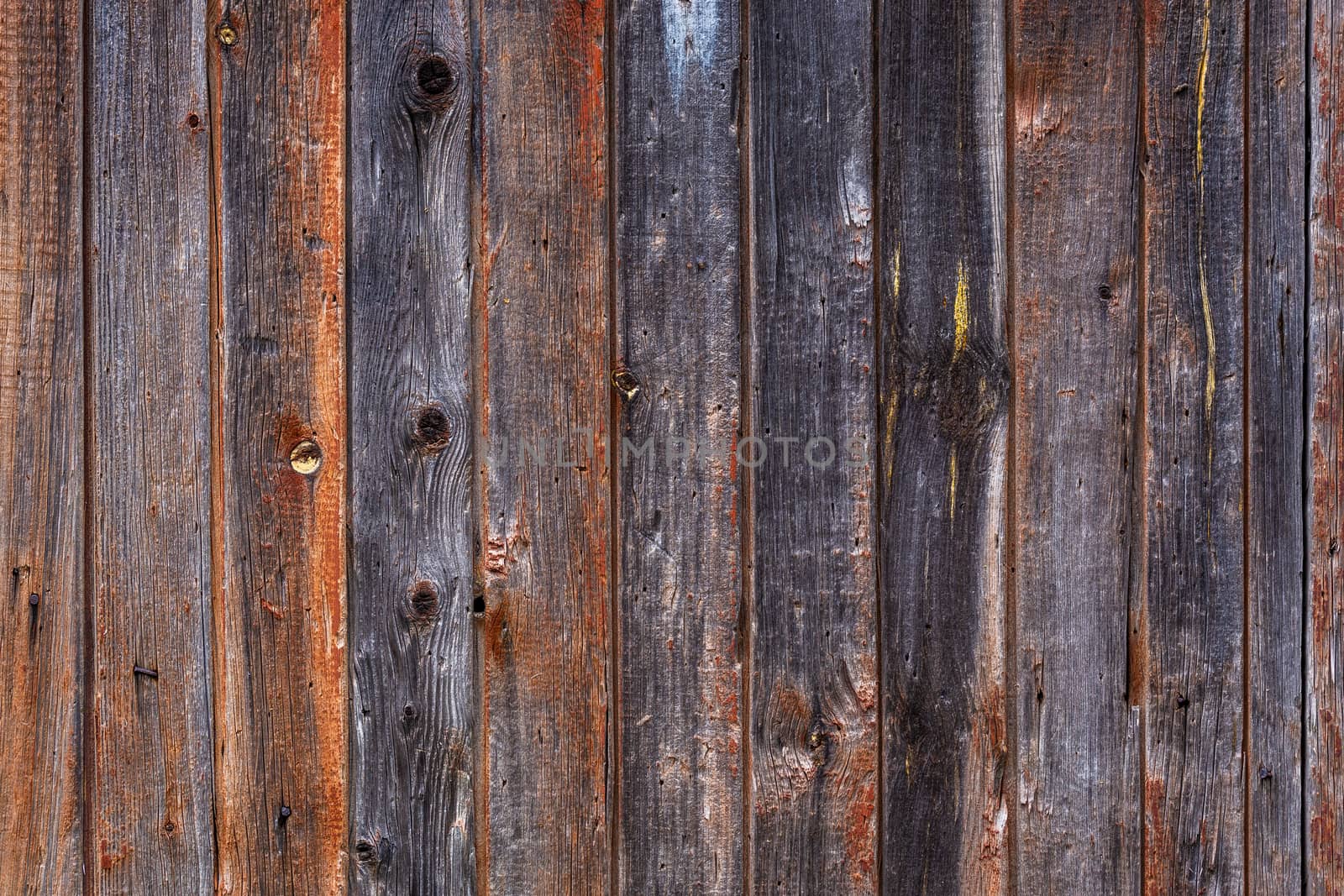 artistic texture of an old wooden planks fence in black and brown tones - close-up rustic background