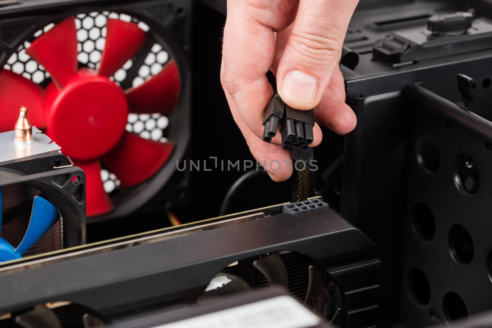 pc engineer hand holding 6 plus 2 pin video card power connector while maintenance.