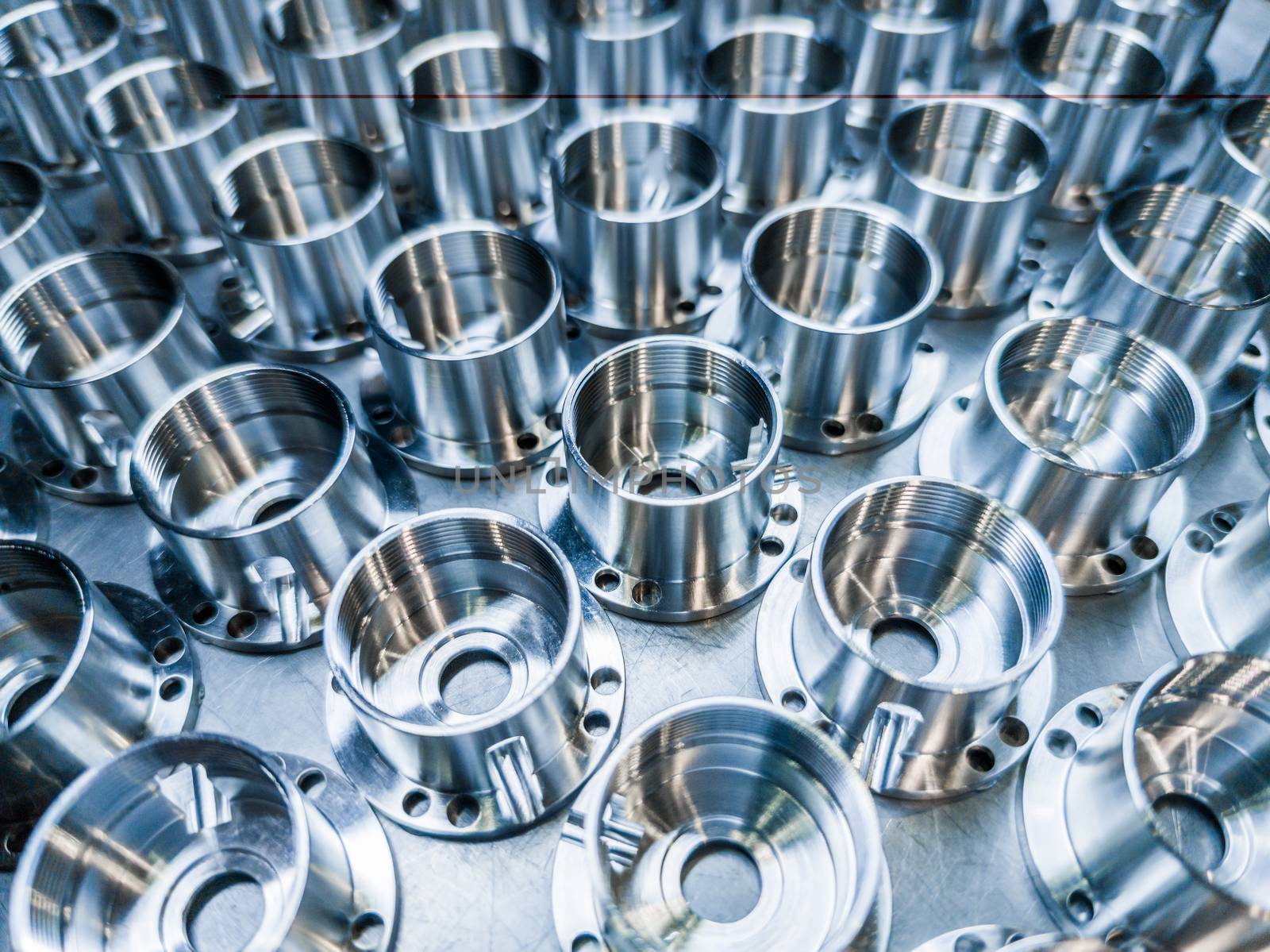 a batch of shiny metal cnc aerospace parts production - close-up with selective focus for industrial background.