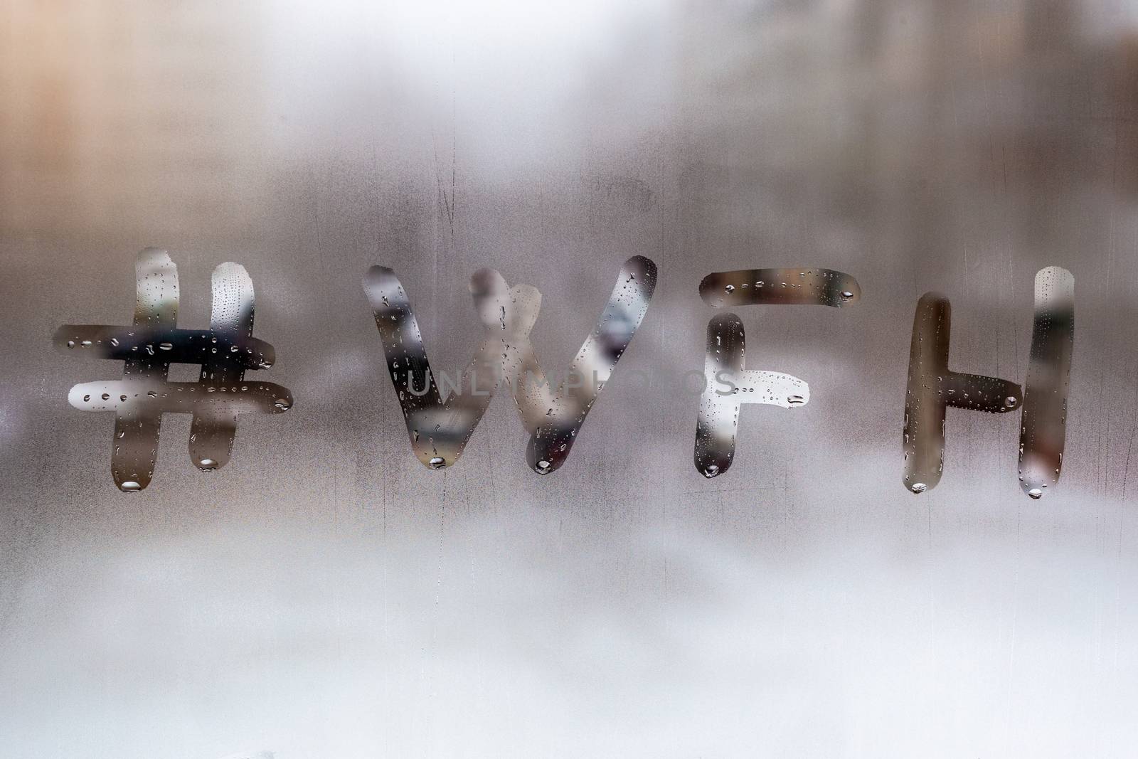 hashtag word wfh - work from home handritten on wet window glass at cloudy weather by z1b