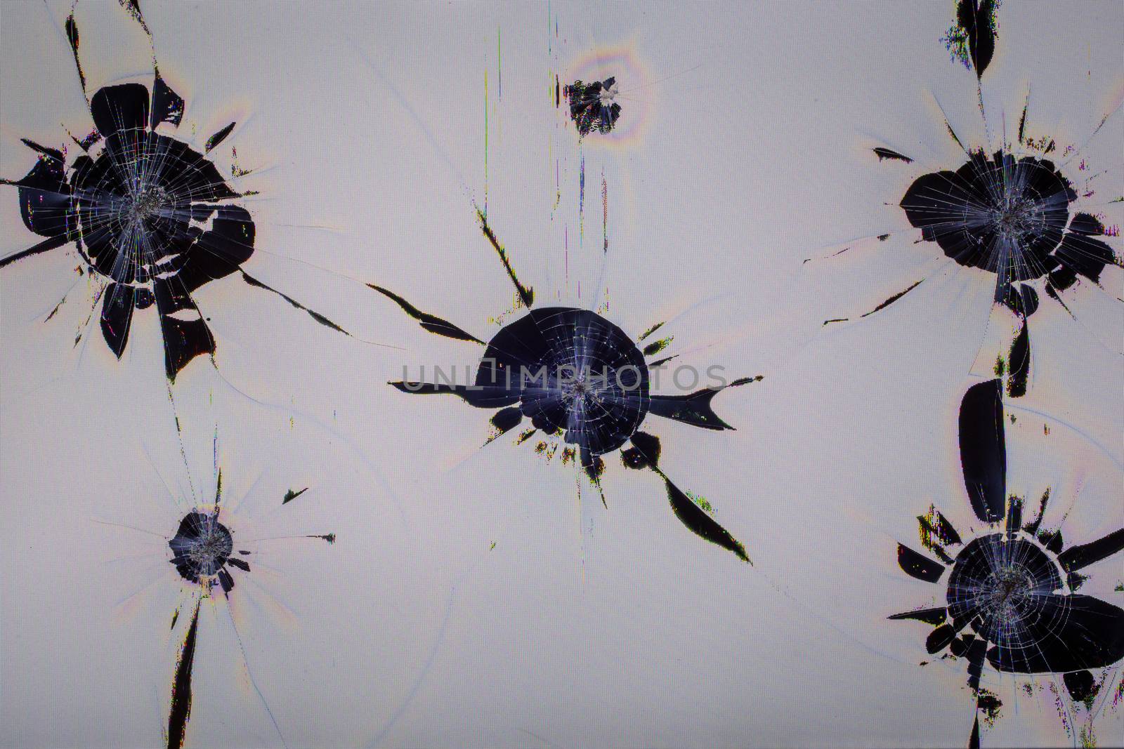Close-up view of physically damaged lcd screen surface with multiple separated impact spots, radial cracks, pixel grid leakage and discoloration. Full frame background of dead monitor.