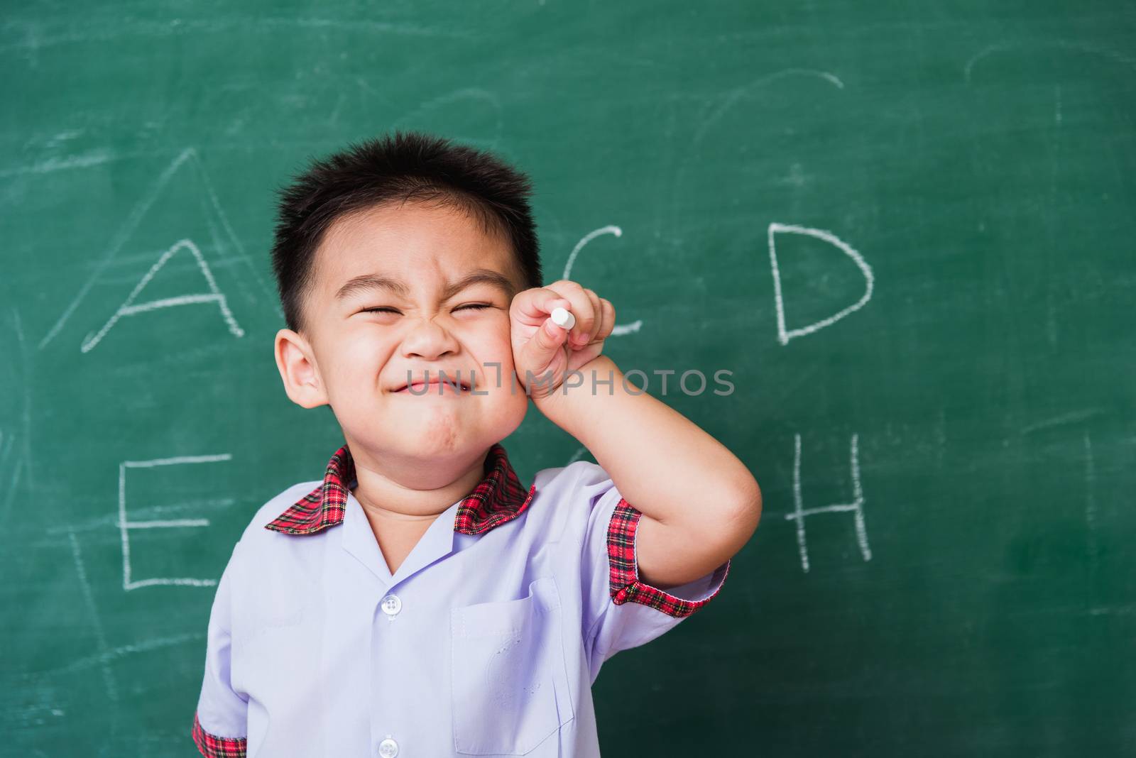 Child boy kindergarten smile in student uniform hold white chalk by Sorapop
