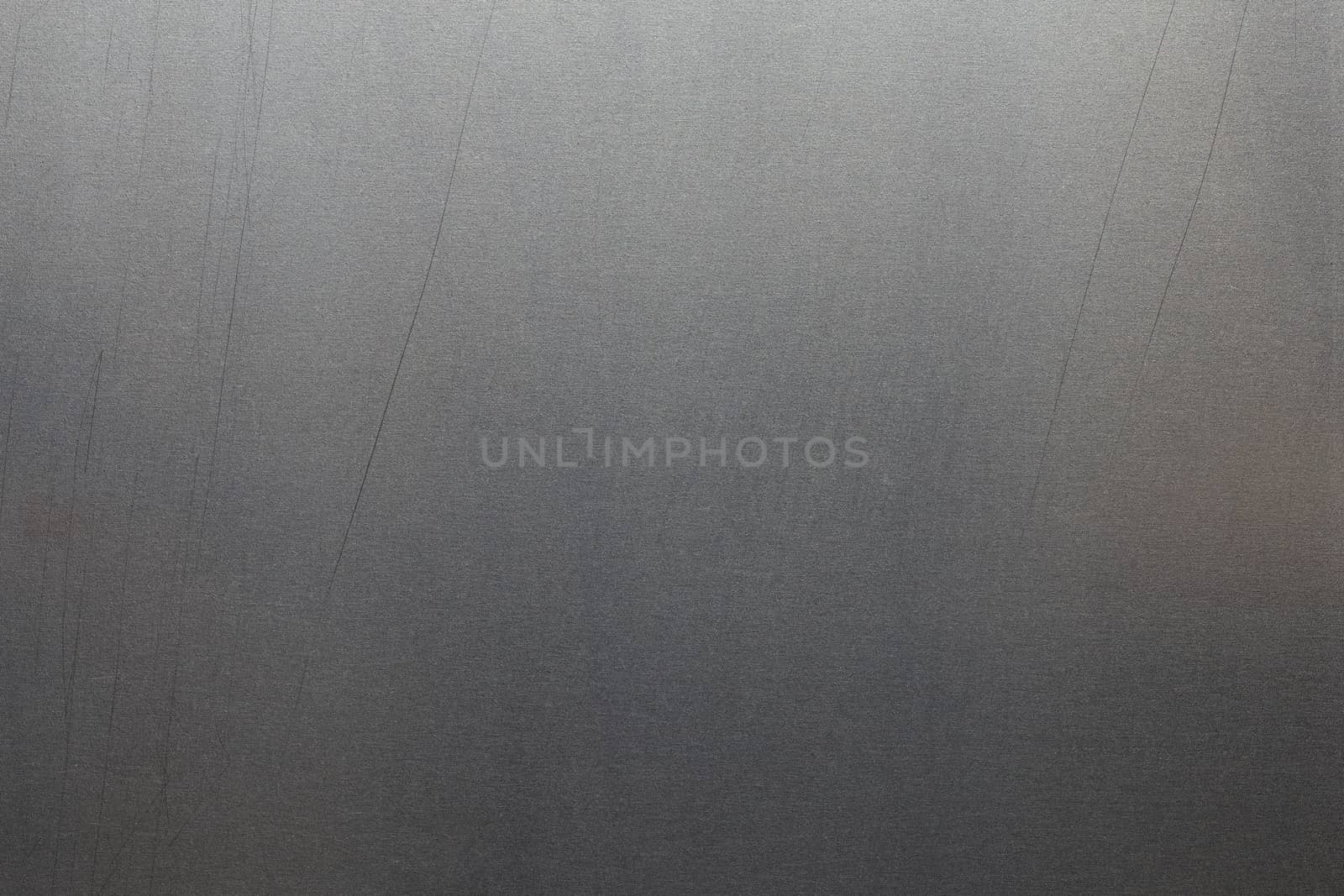 Uncoated flat cold rolled metal sheet surface with minor long scratches. Close-up in directly above composition.