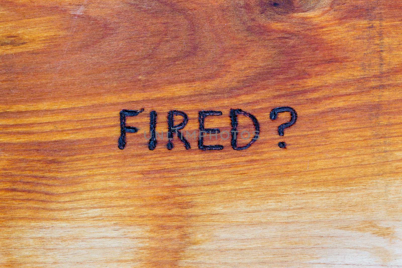 question fired handwritten with hand woodburner on flat brown wood surface in flat lay directly above composition