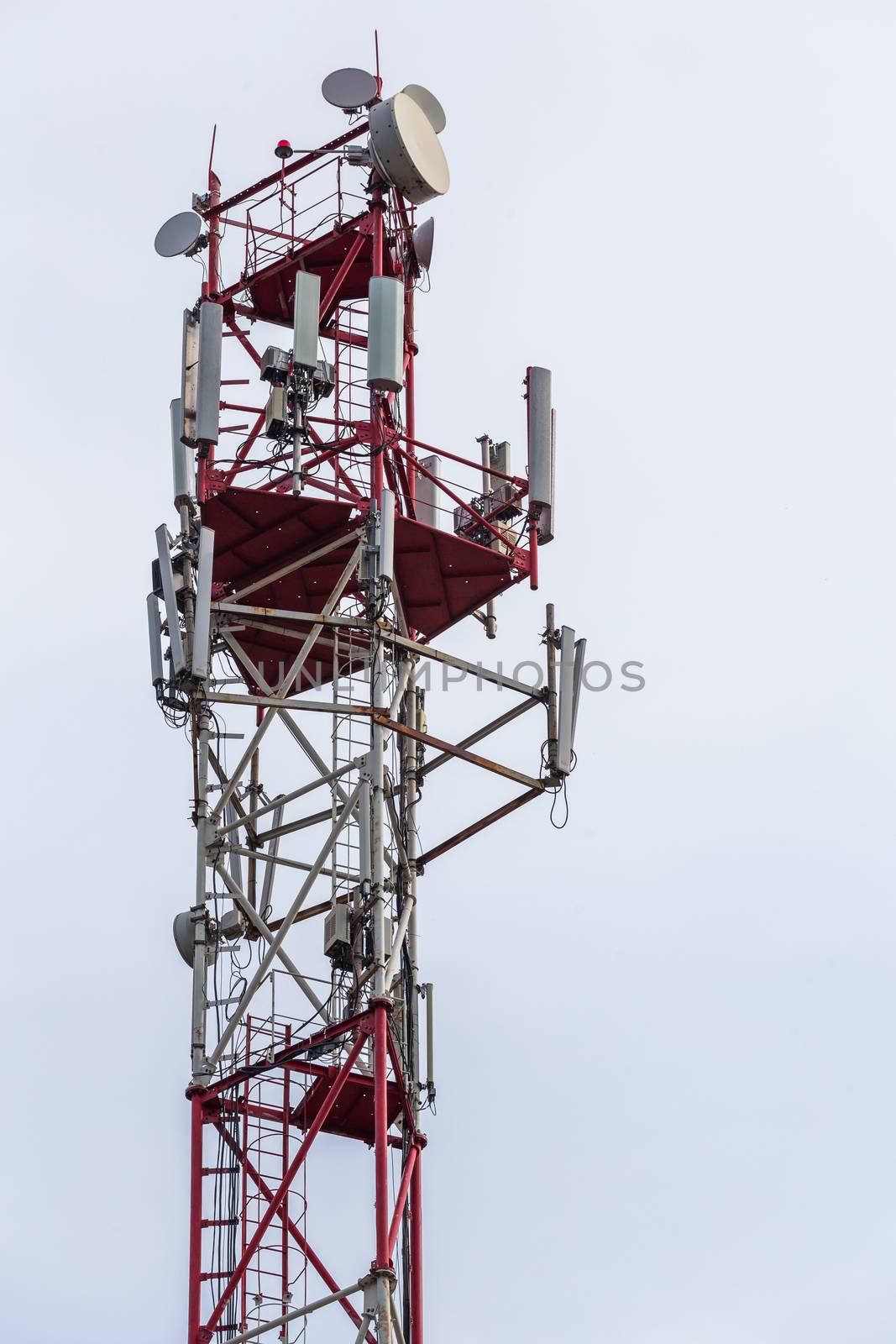 3G, 4G, 5G, wireless and cell phone telecommunication tower close-up on cloudy daylight sky background by z1b