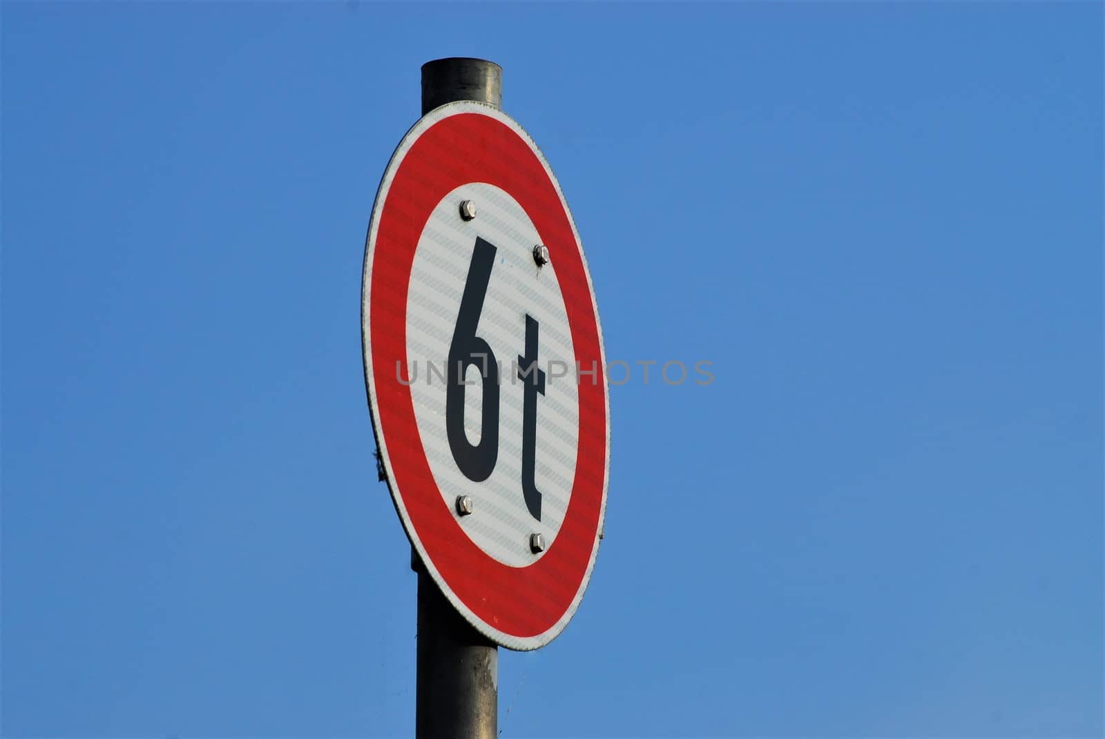 Traffic sign 6t white with red edge against a blue sky