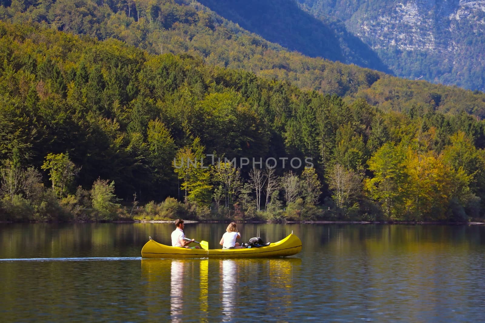 A young couple swims on a boat on a mountain lake or river