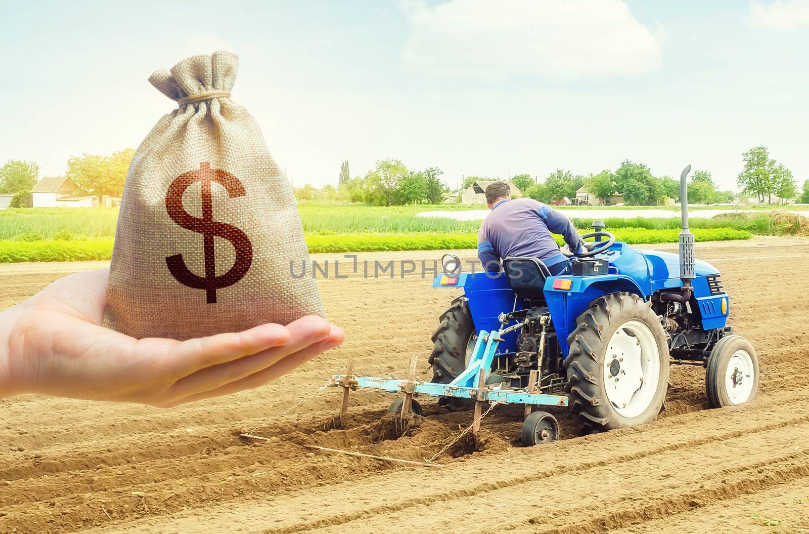 A hand holds out a dollar money bag on a background of farmer on a tractor making mounds rows on a farm field. Lending farmers for purchase land and seed, modernization. Support subsidies. Farm loans by iLixe48