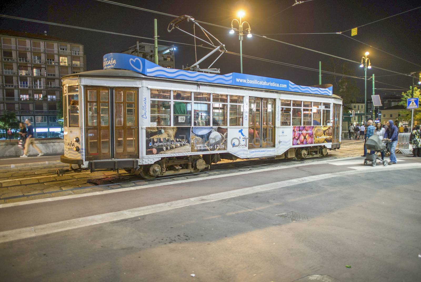 MILAN, ITALY - SEPTEMBER 2015: City tram speeds up along city streets at night.