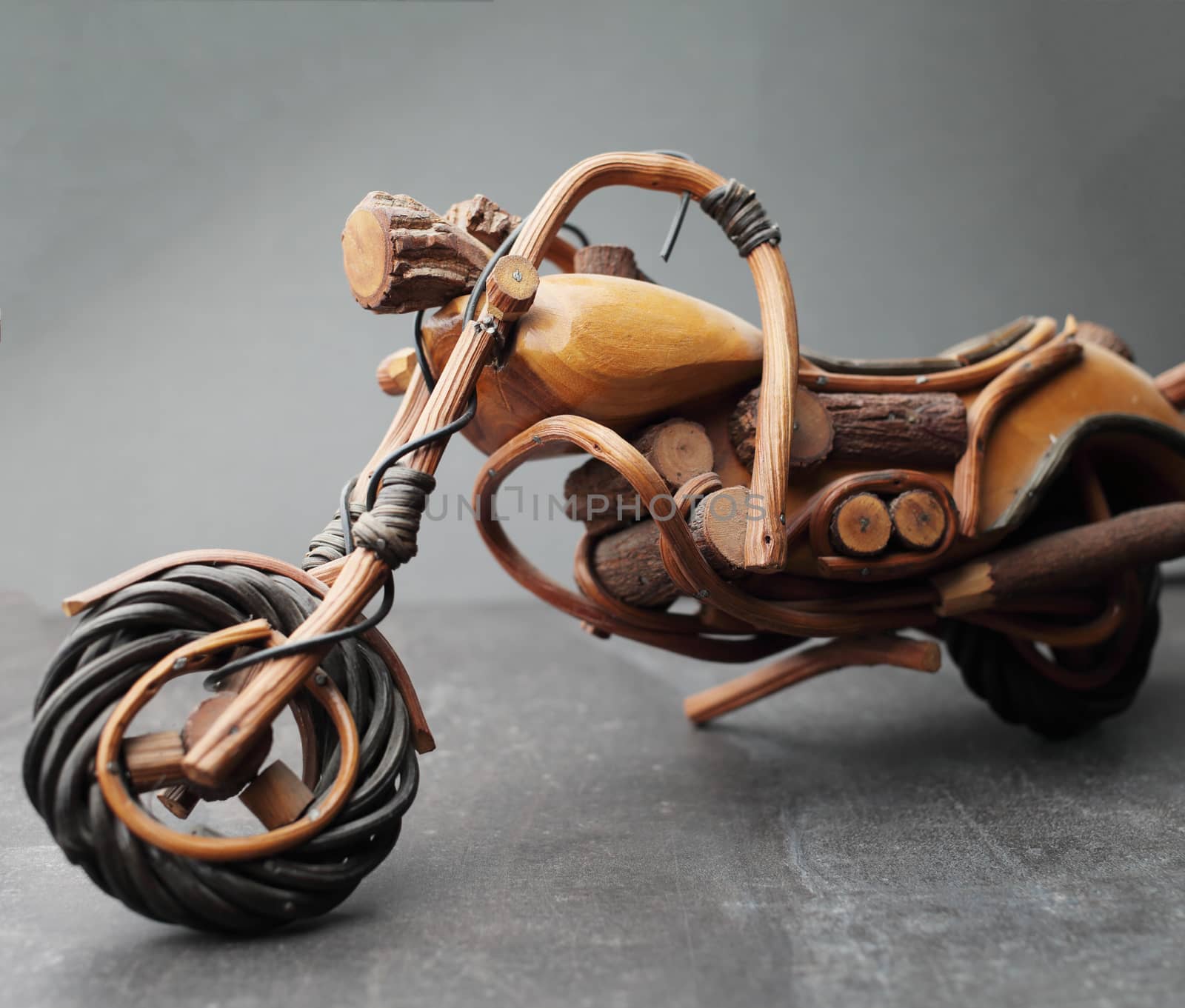 Toy motorcycle made of wood on a gray background by selinsmo