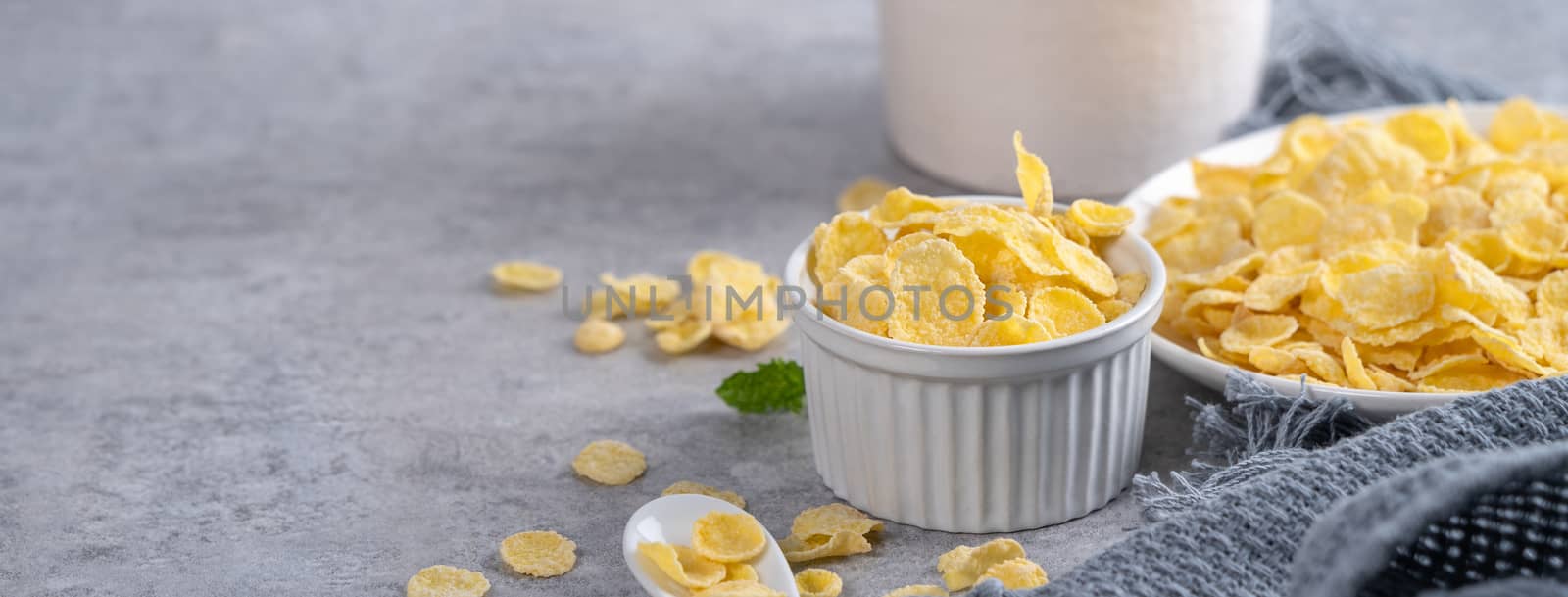 Corn flakes bowl sweeties with milk on gray cement background, close up, fresh and healthy breakfast design concept.