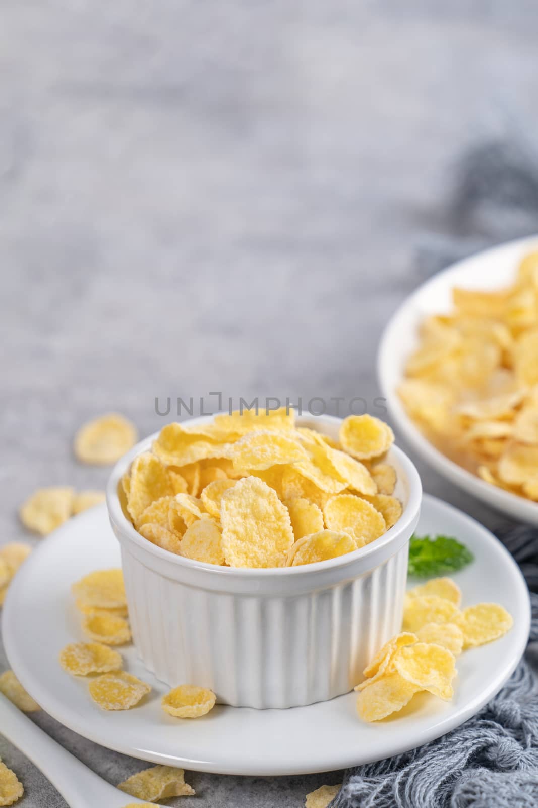 Corn flakes bowl sweeties with milk on gray cement background, c by ROMIXIMAGE