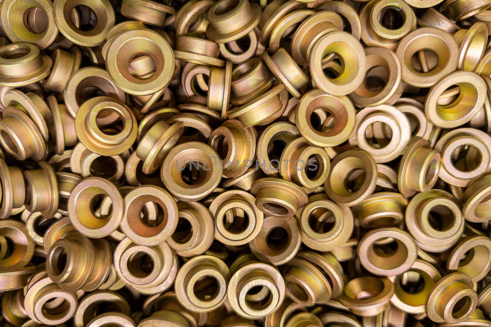 An abstract backround of yellow cadmium coated steel rings. Close-up with selective focus.