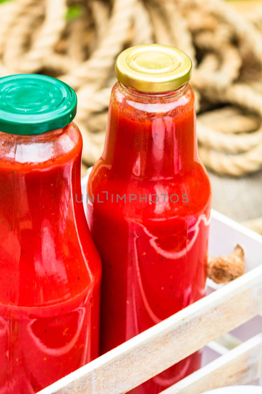 Bottles of tomato sauce, preserved canned pickled food concept isolated in a rustic composition.