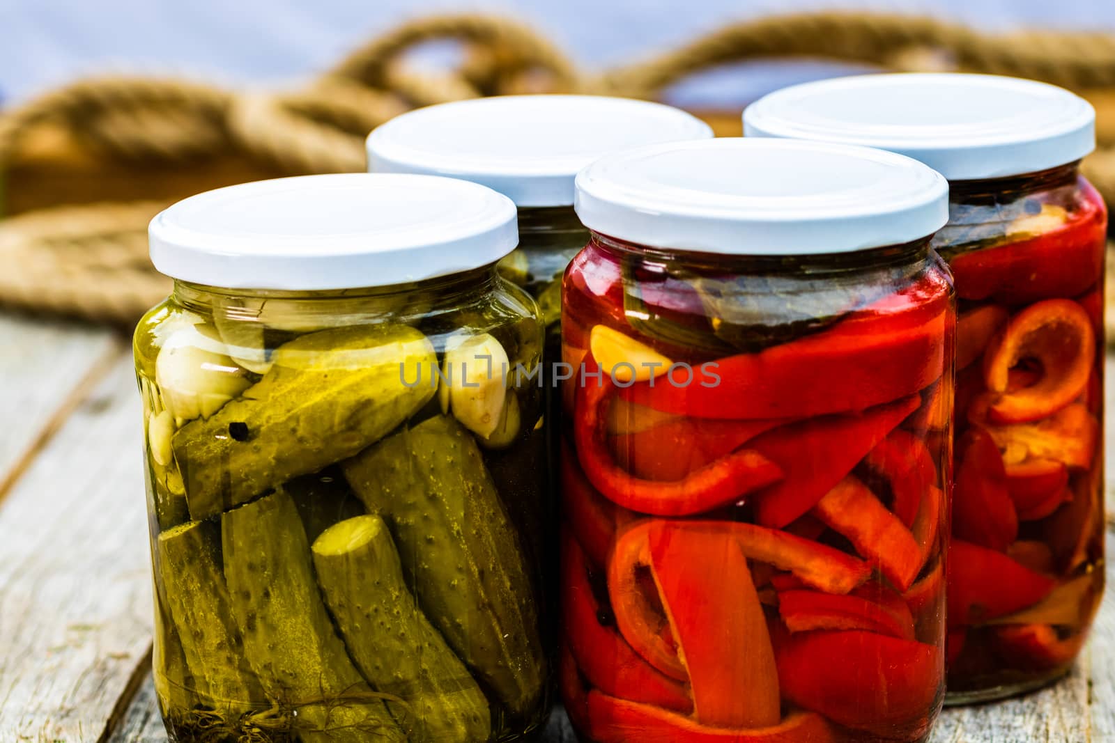 Glass jars with pickled red bell peppers and pickled cucumbers ( by vladispas