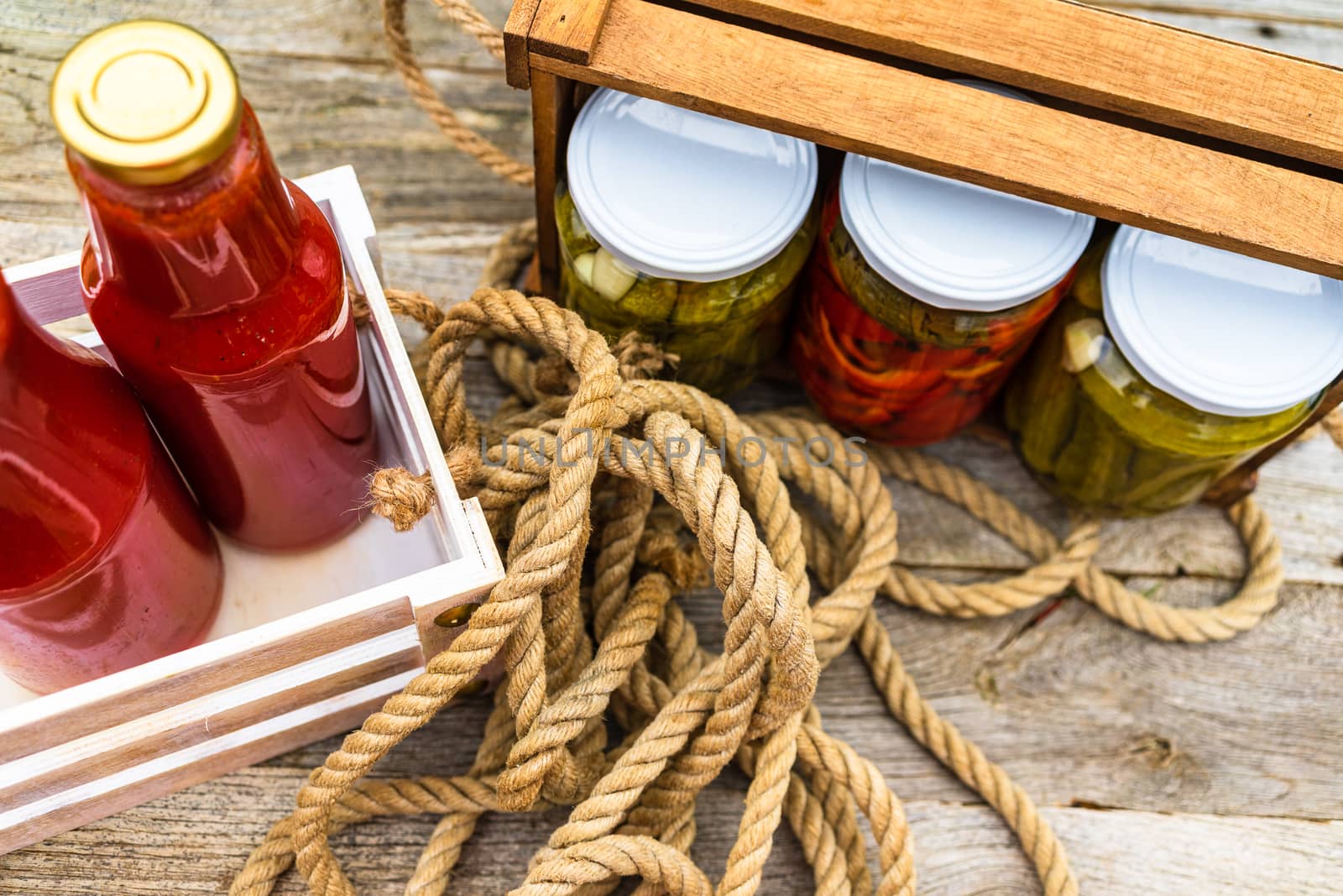 Top view of bottles of tomato sauce, preserved canned pickled food concept isolated in a rustic composition.