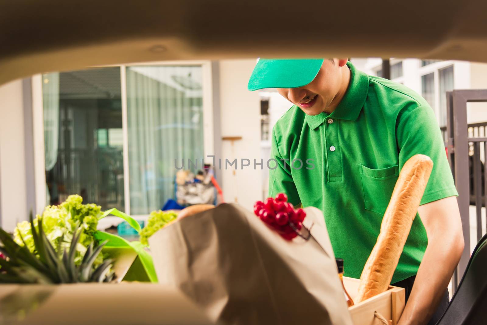 Asian delivery man grocery prepare service giving fresh vegetables food and fruit full in wooden basket on back car to send woman customer at door home after pandemic coronavirus, Back to new normal