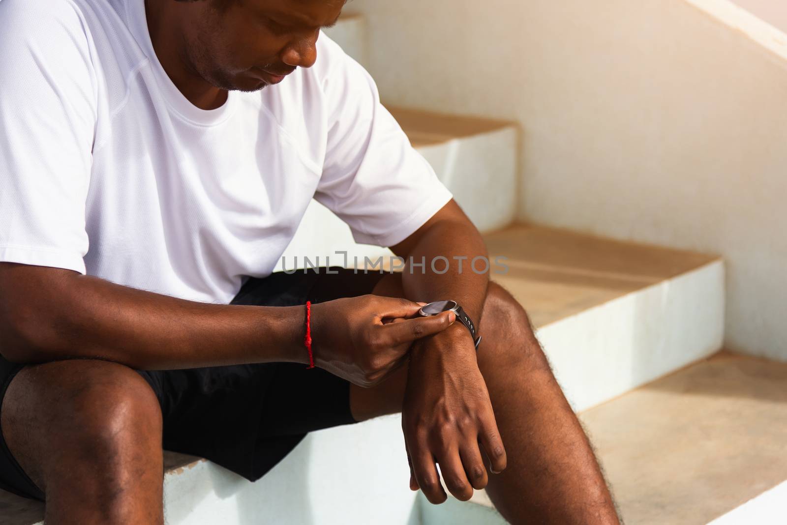 sport runner black man wear modern time smart watch he sitting r by Sorapop
