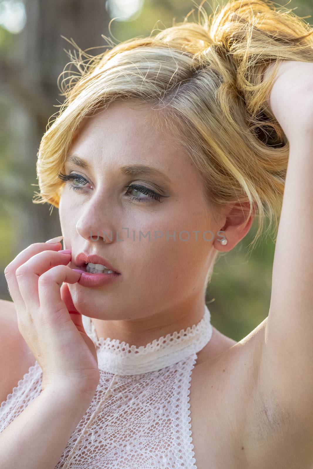 A gorgeous blonde model enjoys a summers day outdoors in a park