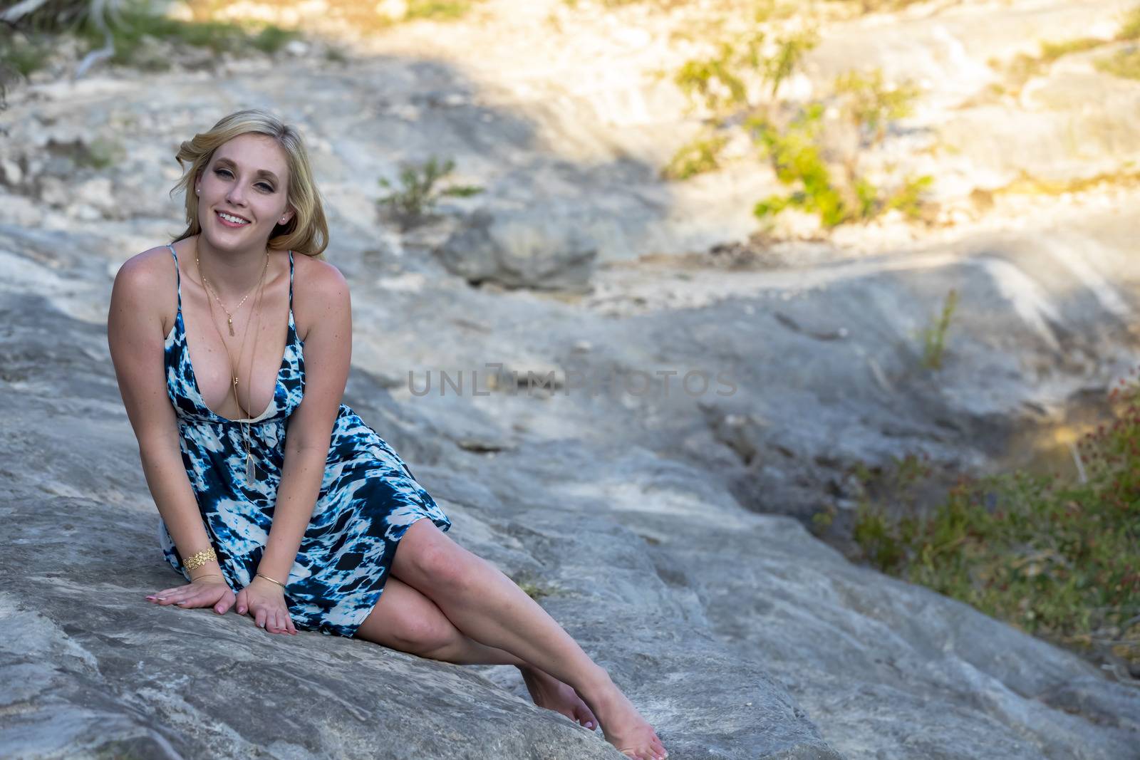 A gorgeous blonde model enjoys a summers day outdoors in a park