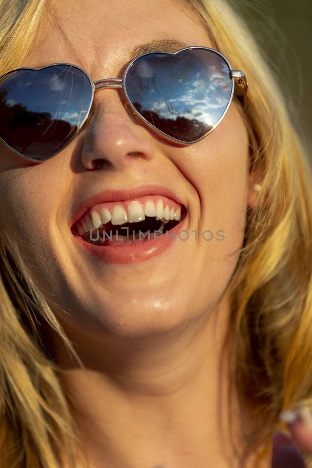 A gorgeous blonde model enjoys a summers day outdoors in a park