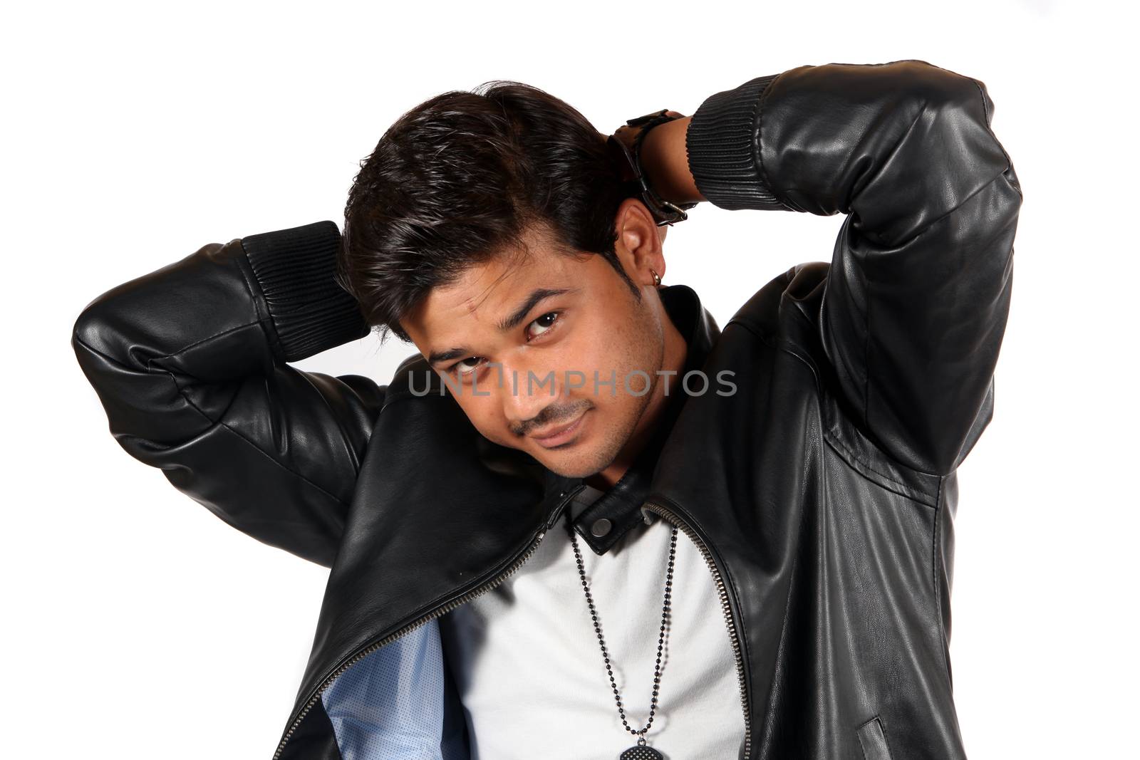 A young handsome Indian guy in a leather jacket, on white studio background.