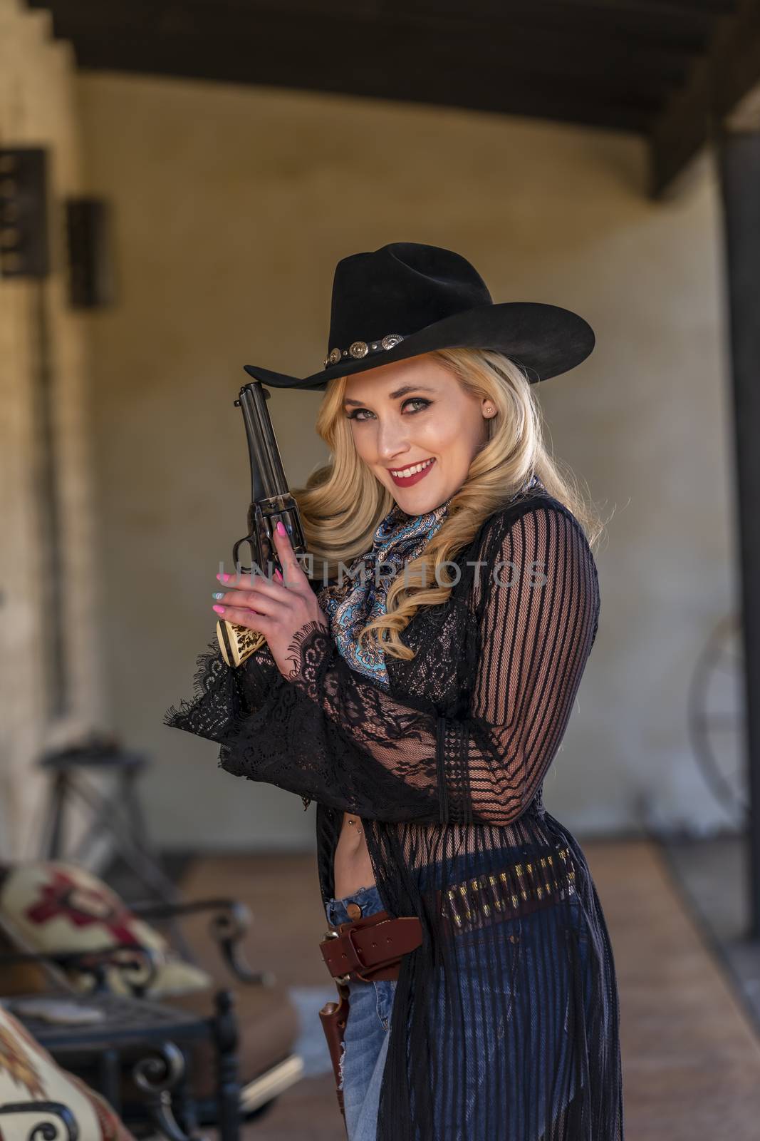 A gorgeous blonde model dressed as a cowgirl enjoying the outdoor weather