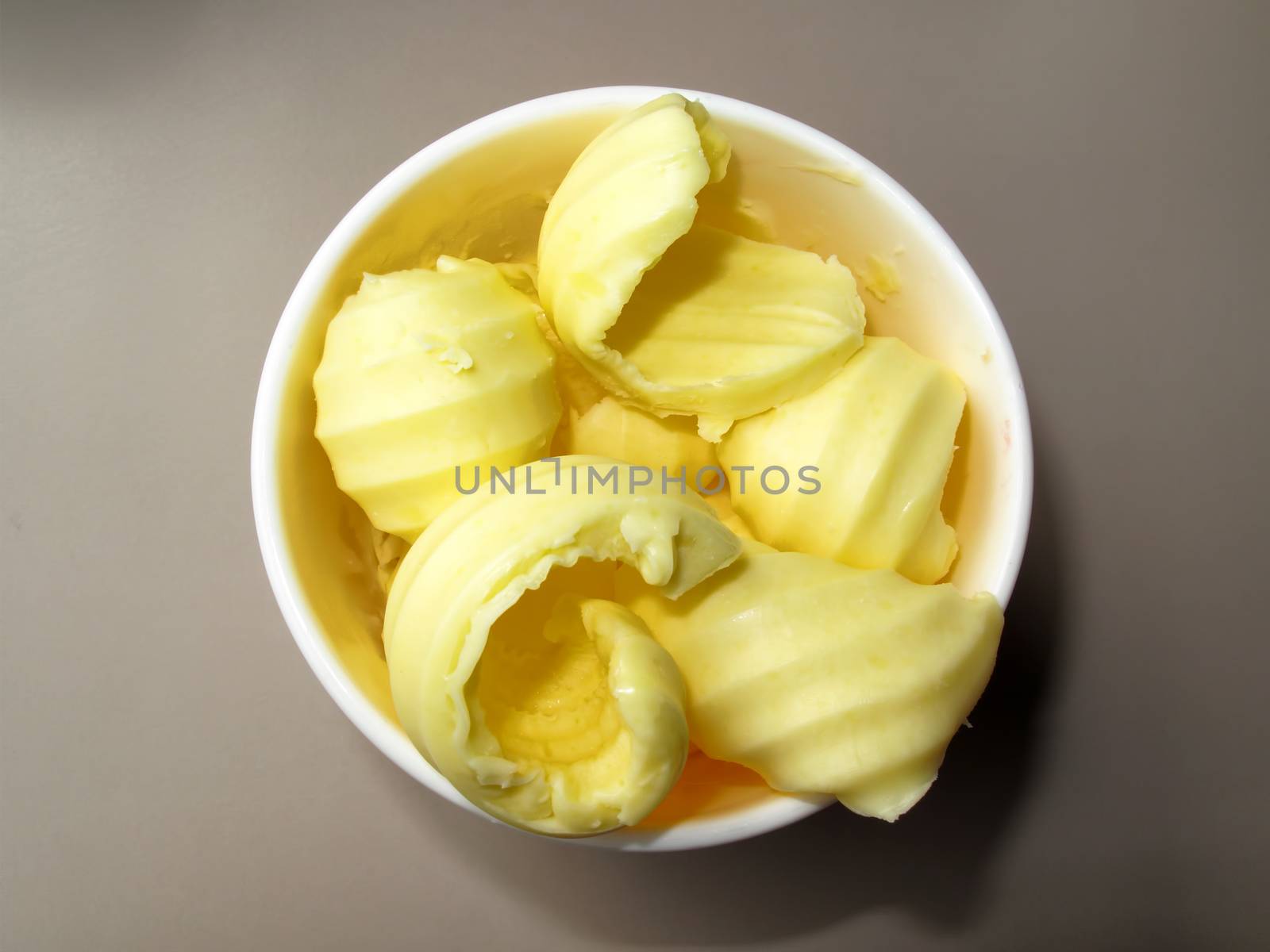 Yellow butter curls in a dish ready to be used stock photo