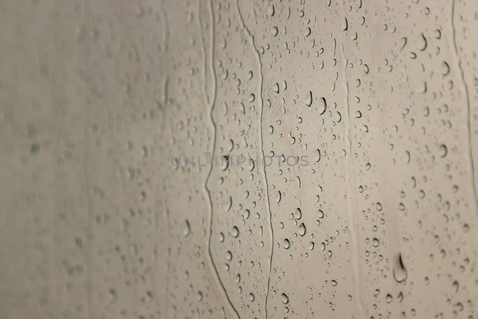 Water rain drops on window glass surface with cloudy background for your design. Natural Pattern of raindrops on glass background. Copy space, No focus, specifically.