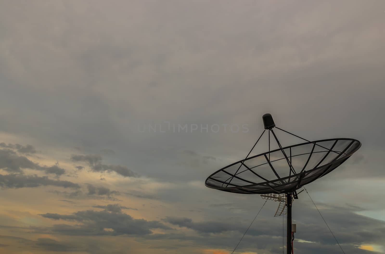 Black Satellite Dish Antenna Receiver Against on Blue Sky background for Communication and Media Industry, Symbolizing Global Communications. Free copy space for text, Selective focus.
