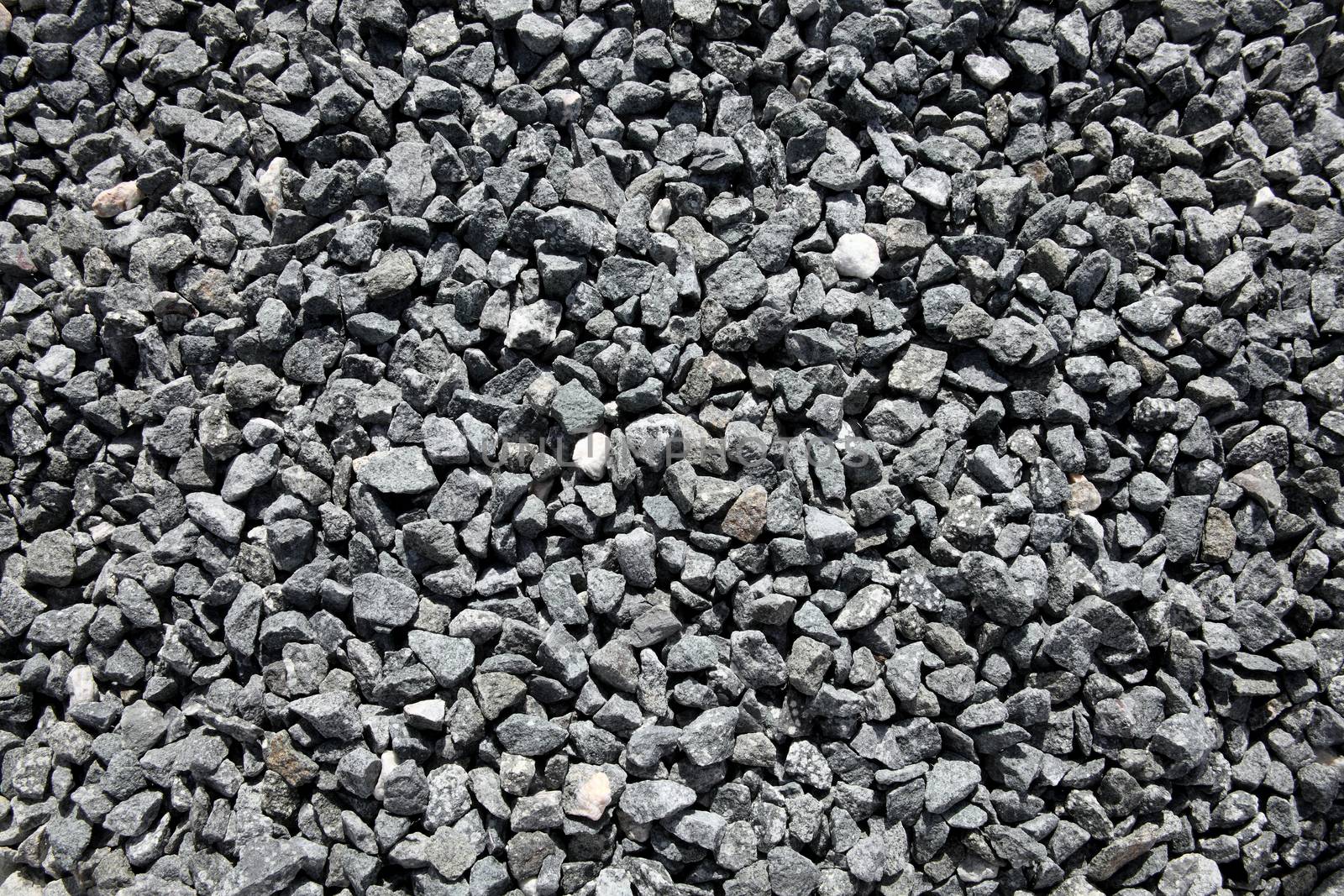 Background texture of grey black, crushed quarry rock pebble stones used for landscaping stock photo