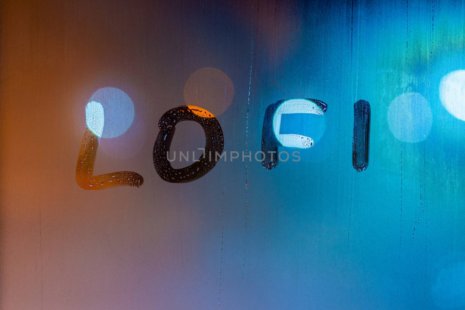 the word lofi written by finger on night wet window glass, blue and orange colors.