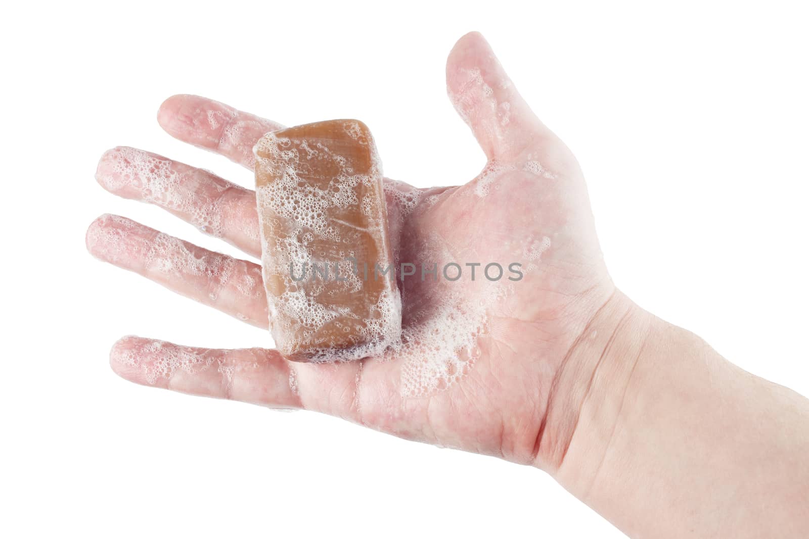 a wet piece of brown tar soap in human hand isolated on white background.