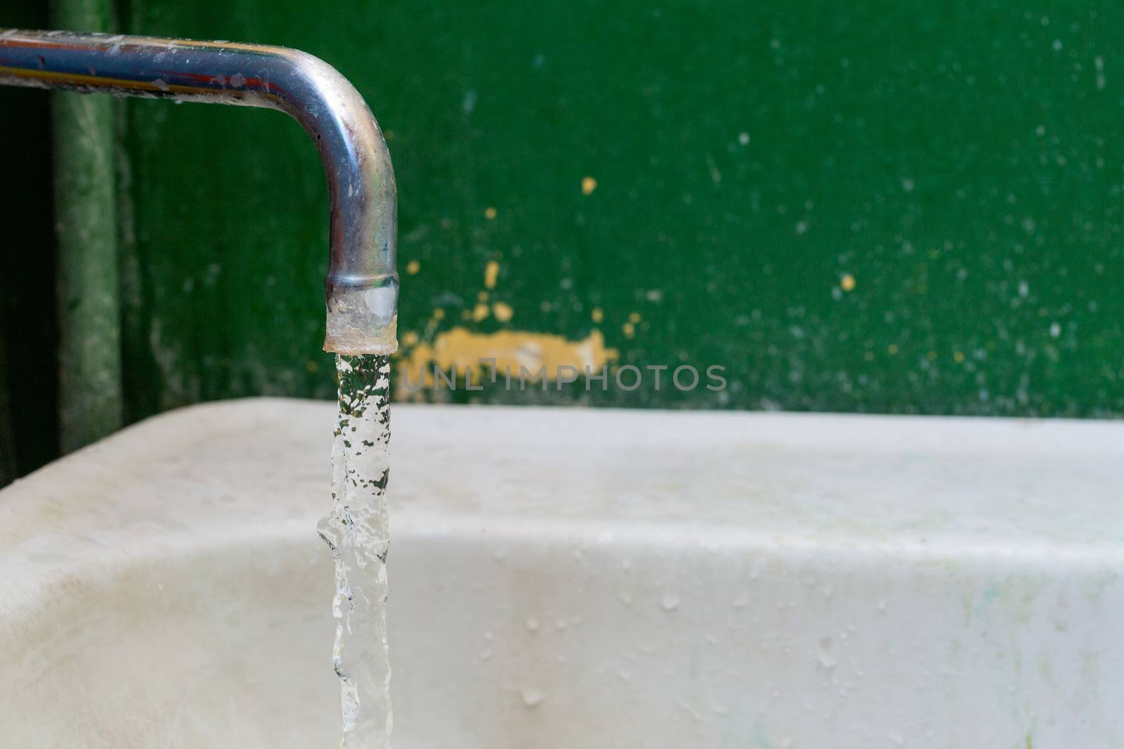 close-up view of old stained water tap with selective focus and background blur.
