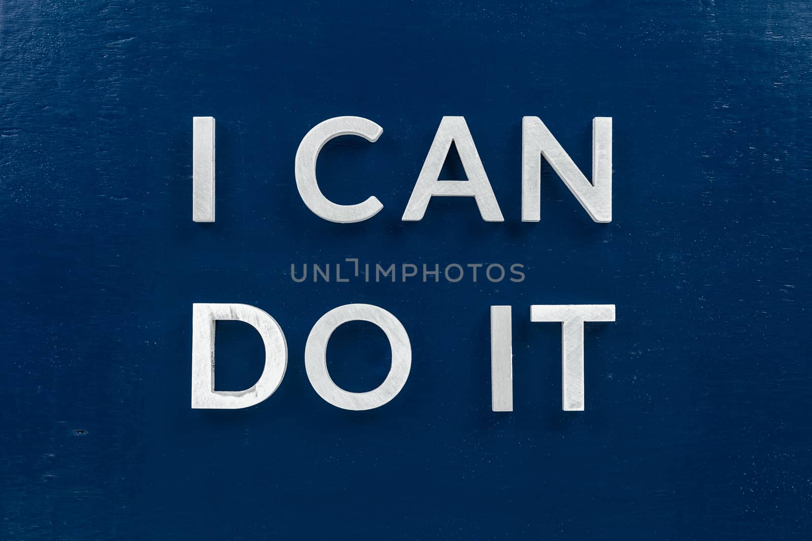 the words i can do it laid with white metal letters on dark blue flat background.