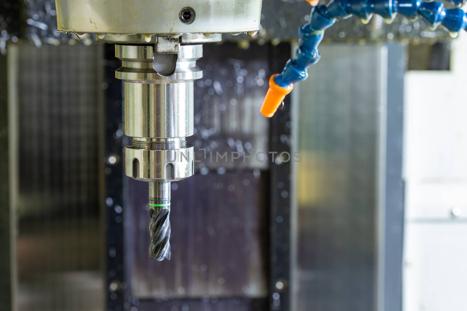 wet carbide mill and collet chuck in vertical cnc milling machine with blue plastic hose system for coolants and air