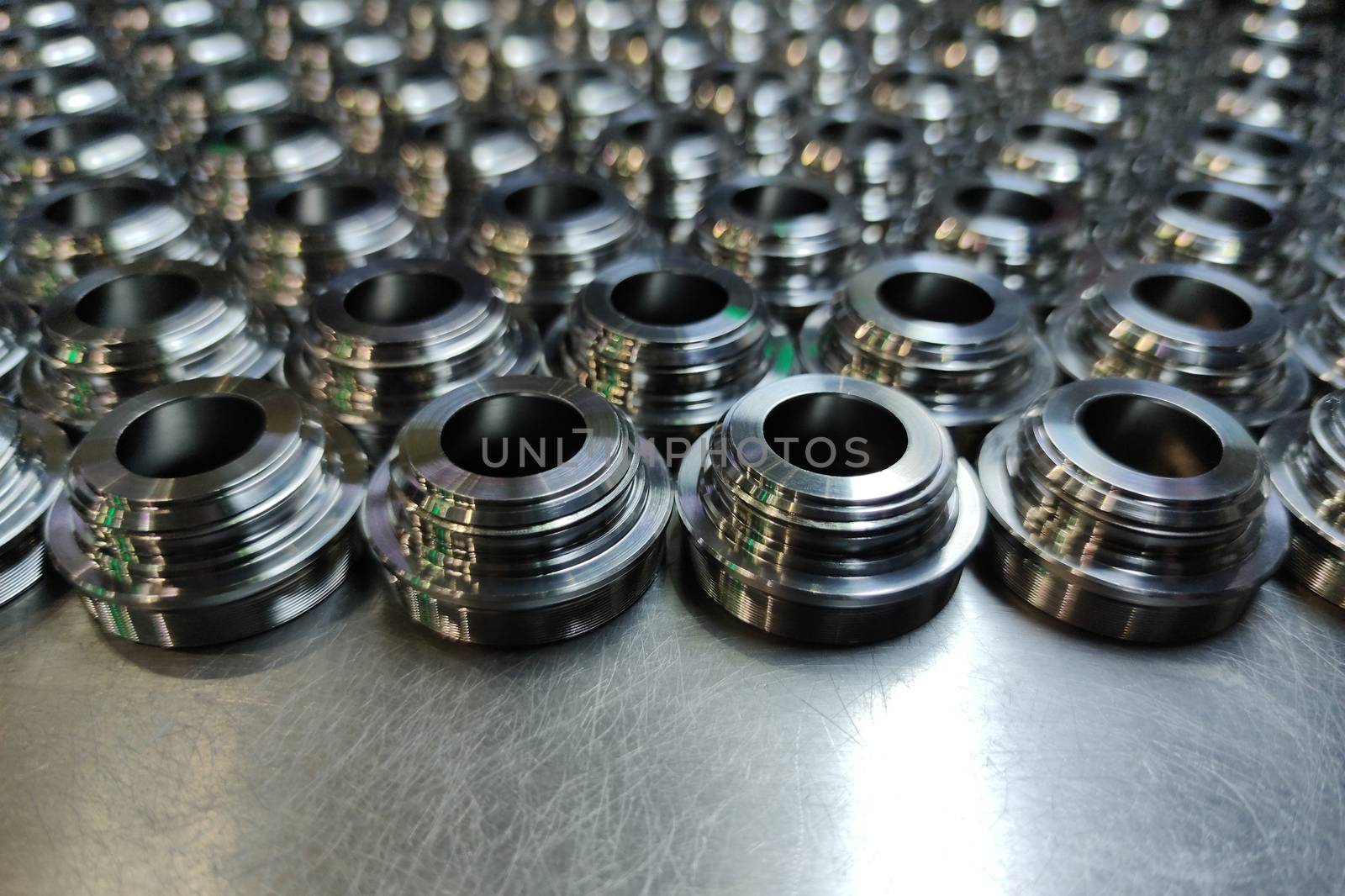 a batch of shiny metal cnc aerospace parts production - close-up with selective focus for industrial background by z1b