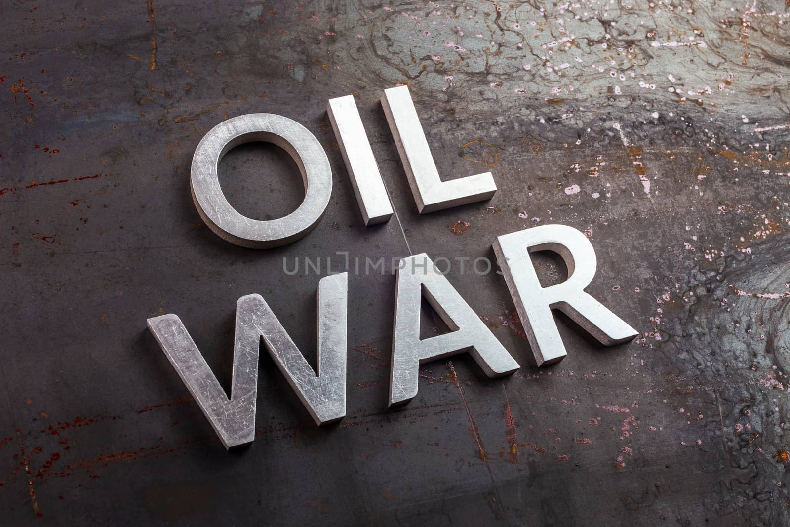 words oil war laid with silver metal letters on rusted heavy hot rolled uncoated steel sheet surface in slanted diagonal perspective