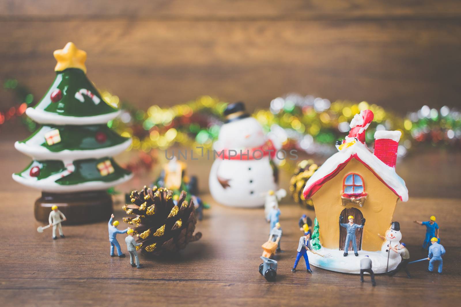 Creative concept with miniature people creating Christmas decorations on a wooden background. , Concept of teamwork.