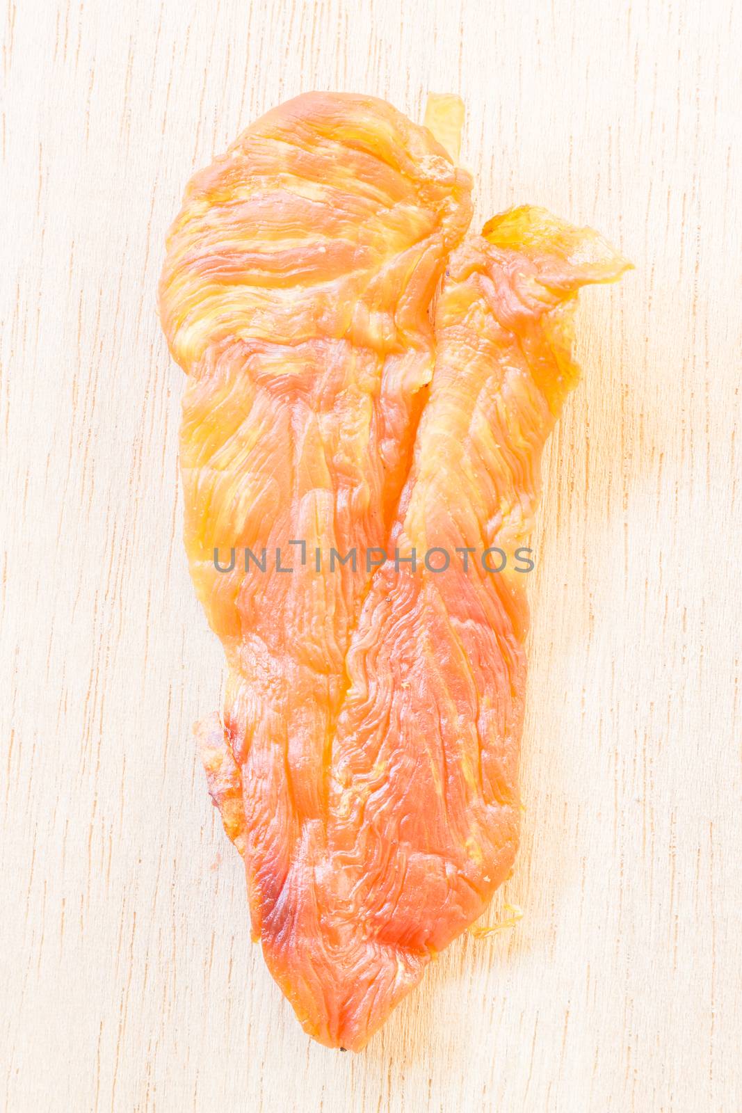 Dried chicken jerky for dogs on wooden background