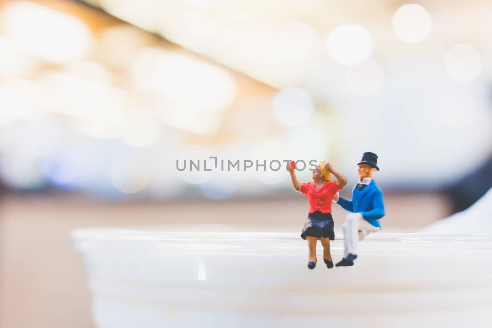 Miniature people : Couple sitting on cup , Valentine day's concept