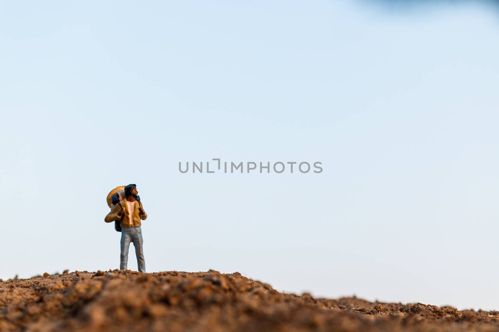 Miniature people : Traveler with backpack mountaineering. Hiking man with backpack walking outdoor