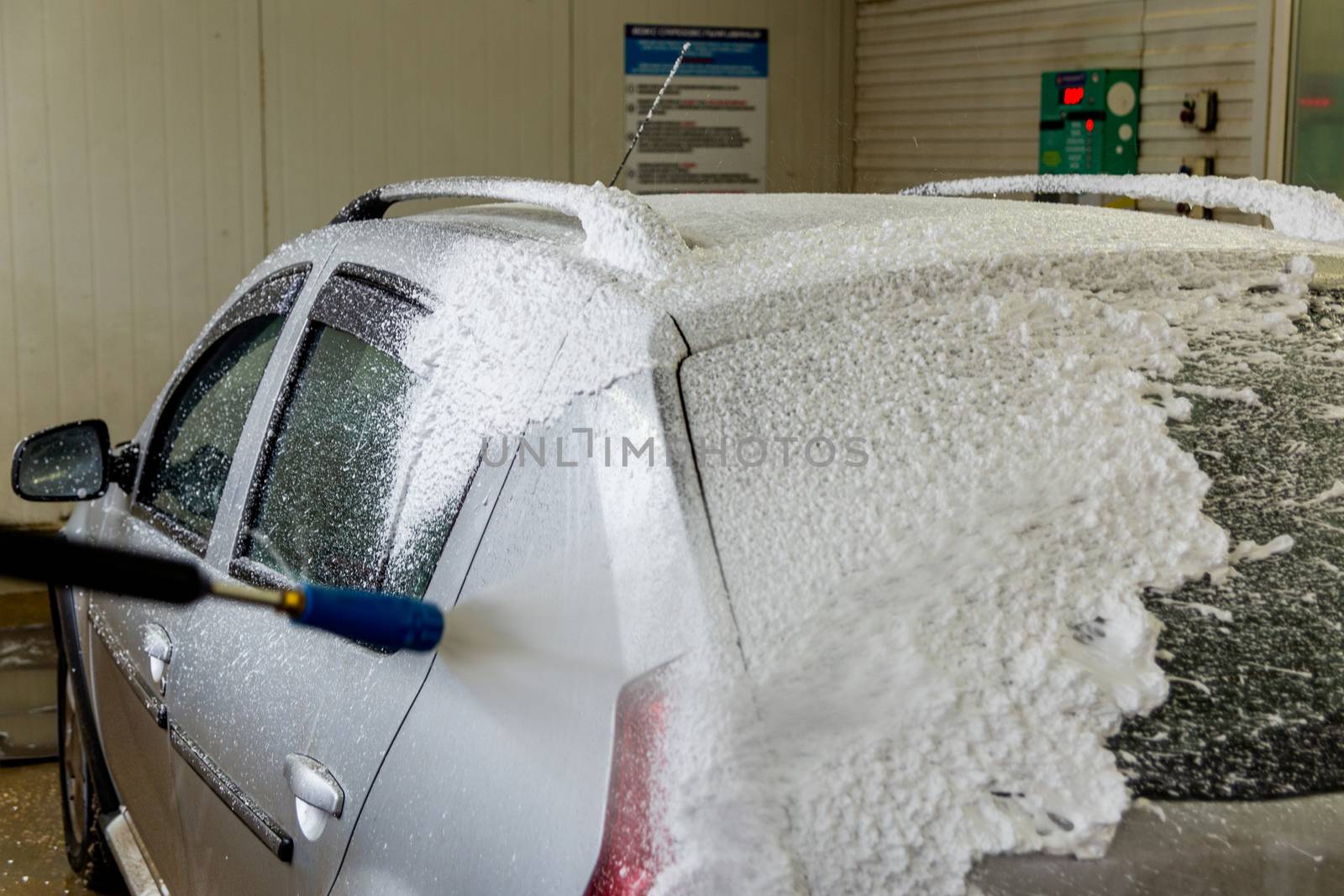 a car foam application process while washing indoors.