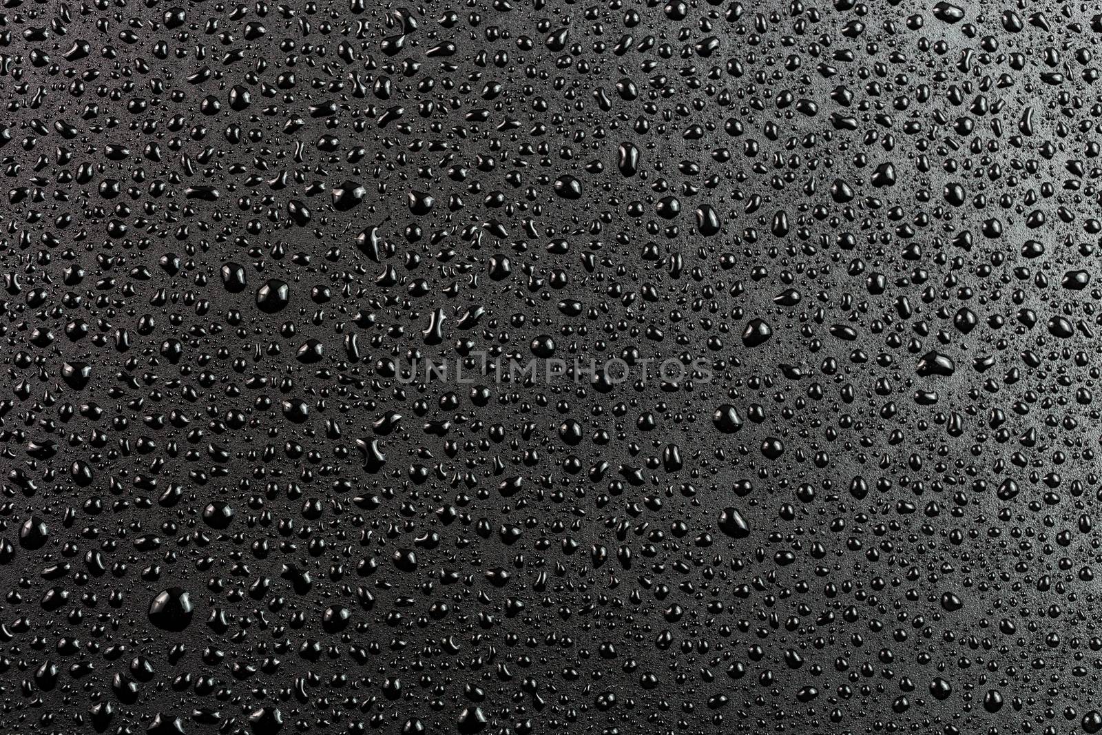 water drops on abstract flat black hydrophobic surface macro background by z1b