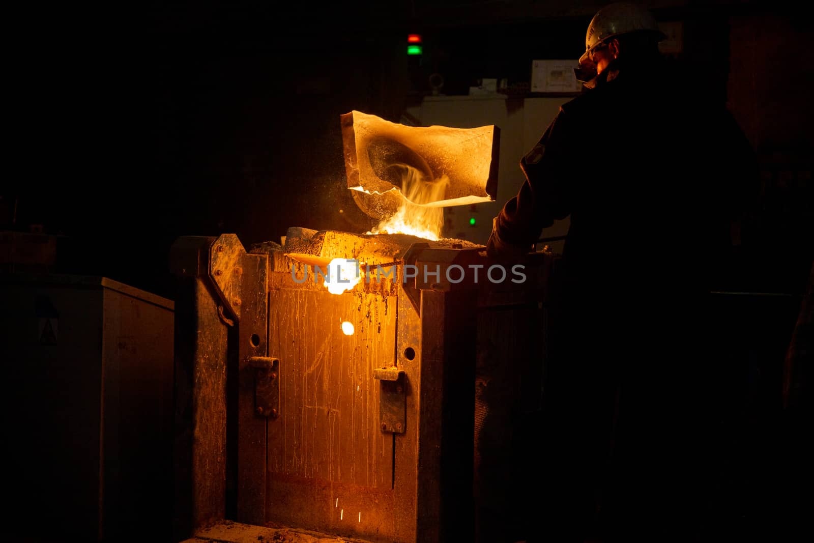 worker removing slag from metallurgical furnace with exhaust hood and melting metal with vapor by z1b