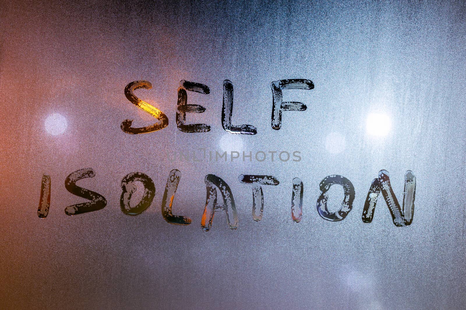 the words self isolation handwritten on wet window glass at night - close-up fuul frame picture with selective focus by z1b