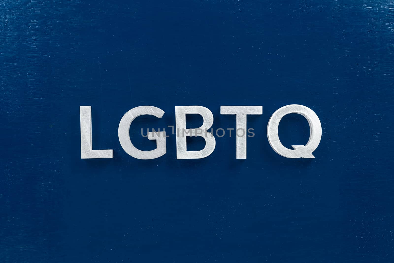 the abbreviation lgbtq - lesbian, gay, bisexual, transgendered, and queer laid with white letters on dark blue flat background - in center of picture, directly above view