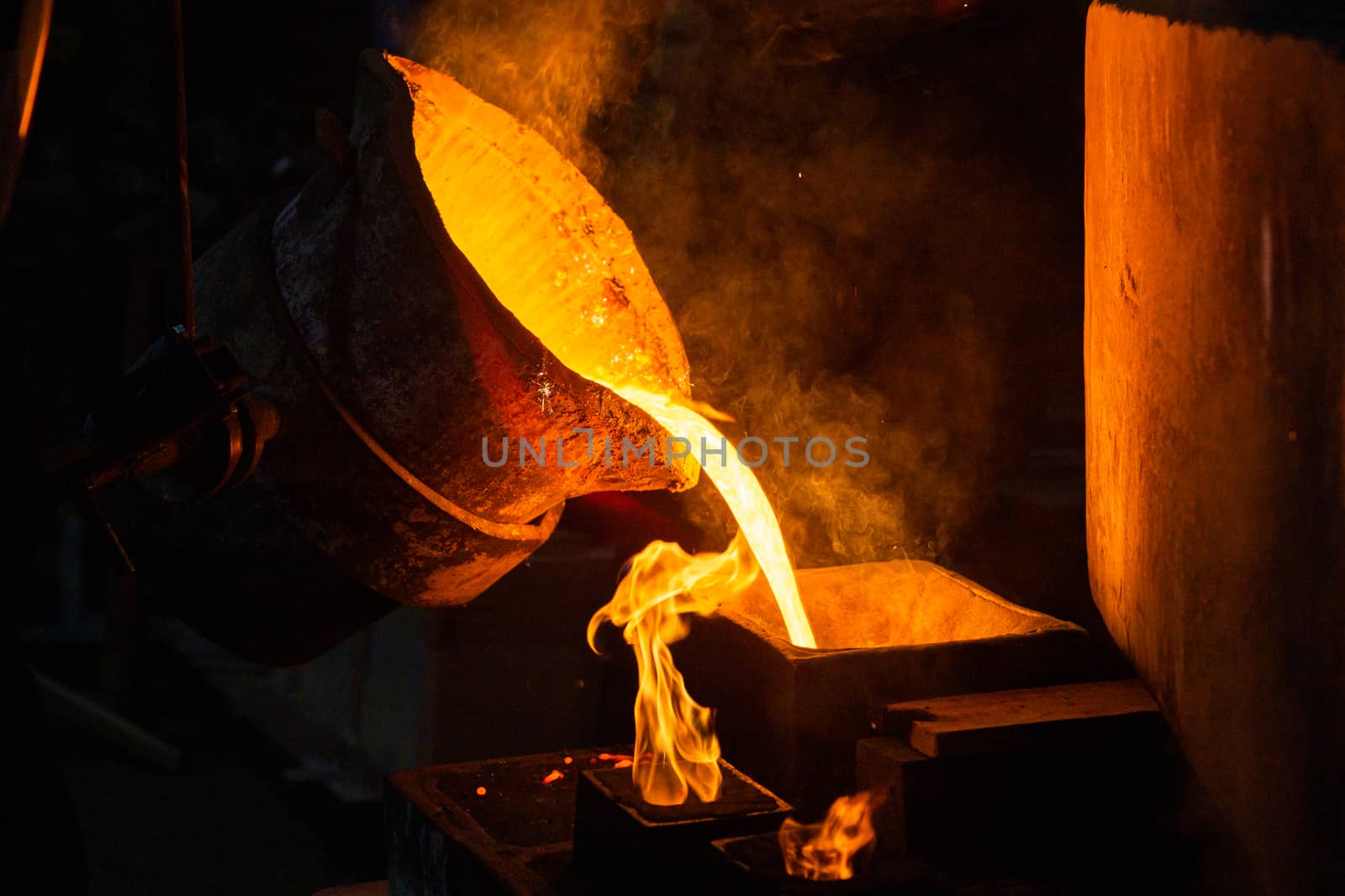 Close-up view of industrial chill casting with selective focus. The process of for filling out mold with molten metal.