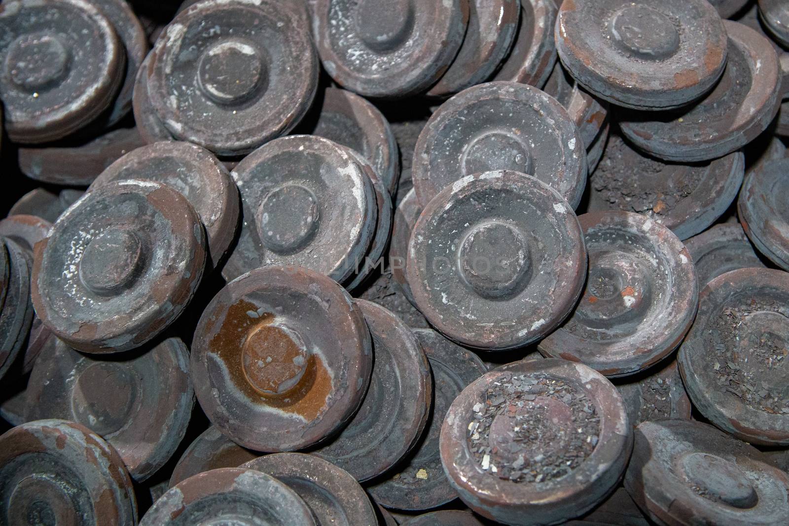 heap of grey steel round forgings - close-up natural heavy industrial pattern with selective focus and grim mood